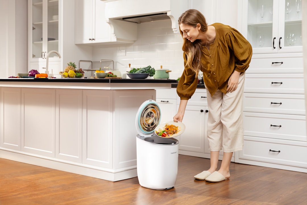 A woman carefully sorting household waste into recycling bins in a small London flat kitchen