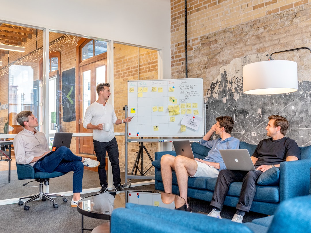 A London startup founder presents a pre-seed funding pitch to a group of angel investors in a modern meeting room