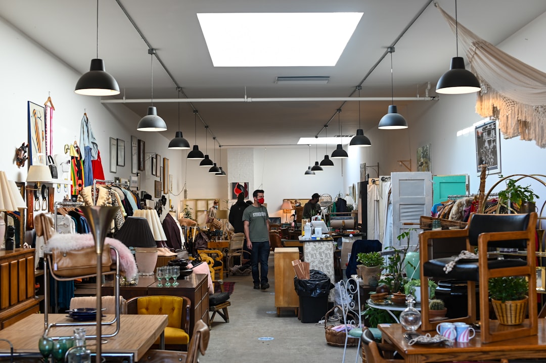 A man examining second-hand chairs at a London warehouse, exploring ethical furniture sourcing in the city.