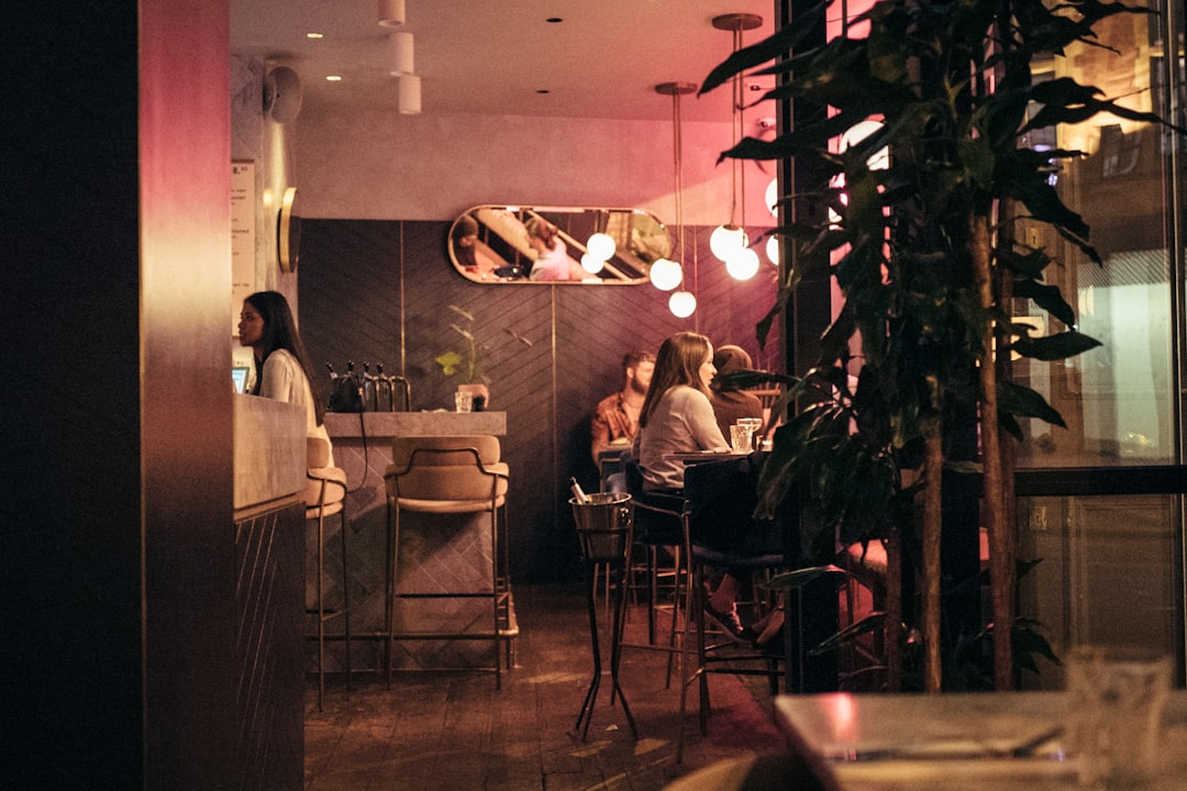 A woman enjoying exclusive dining at one of London's top members clubs, surrounded by elegant interiors