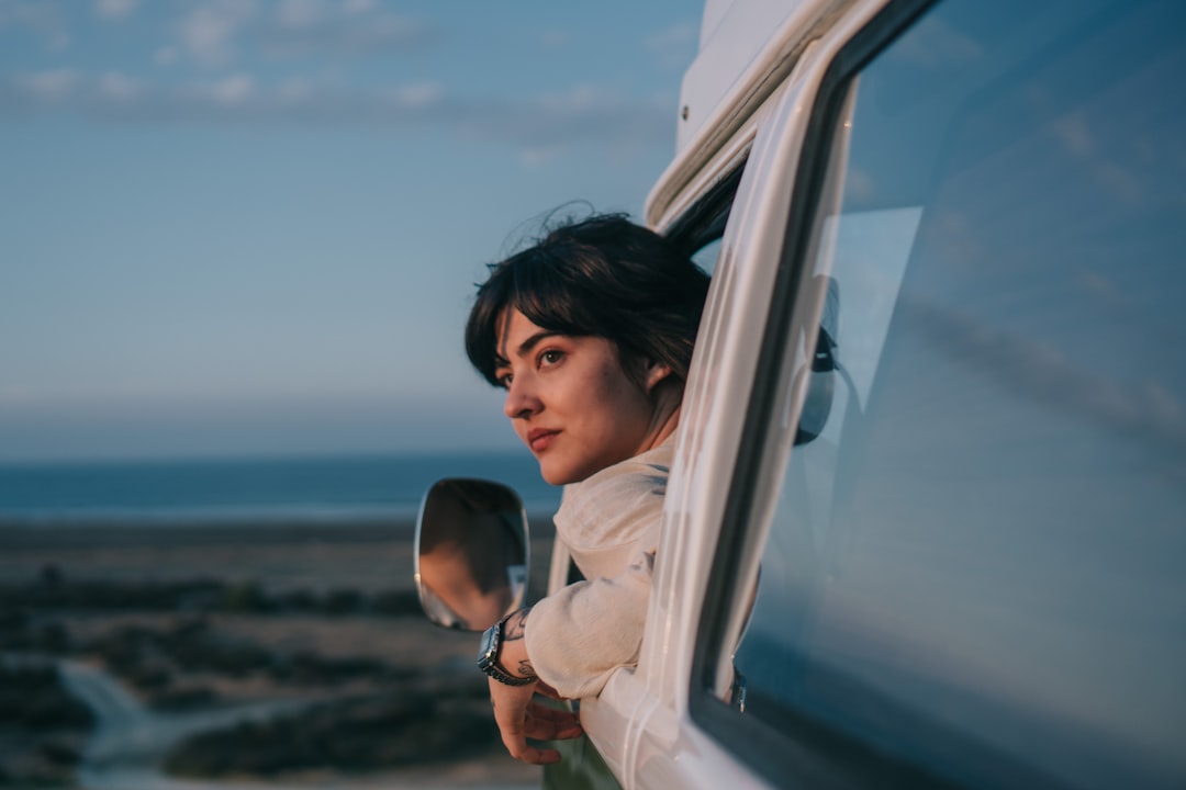 A woman looks out of a car window as she travels toward one of the coastal escapes from London on a bright summer afternoon.