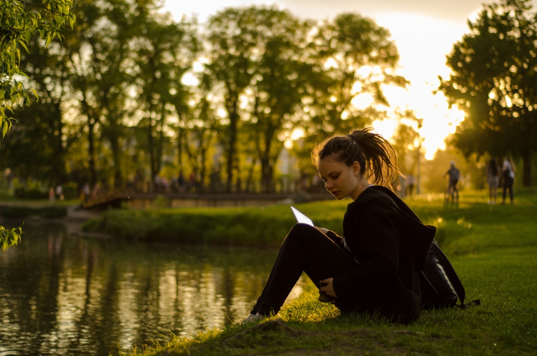 A woman relaxing on the grass at golden hour during a London summer evening in one of the city's Royal Parks