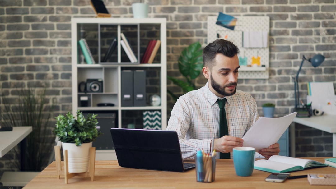 A business owner carefully reviewing a commercial lease agreement in a bright London studio space