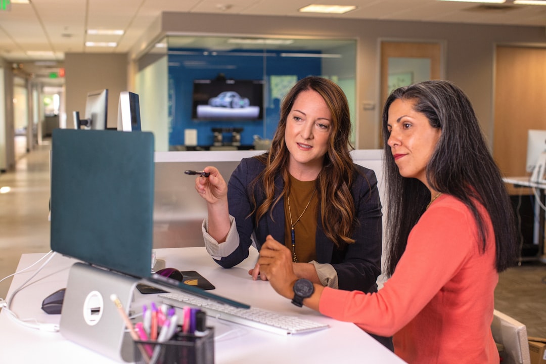 An experienced business mentor in London reviews a startup plan with a young founder at a desk
