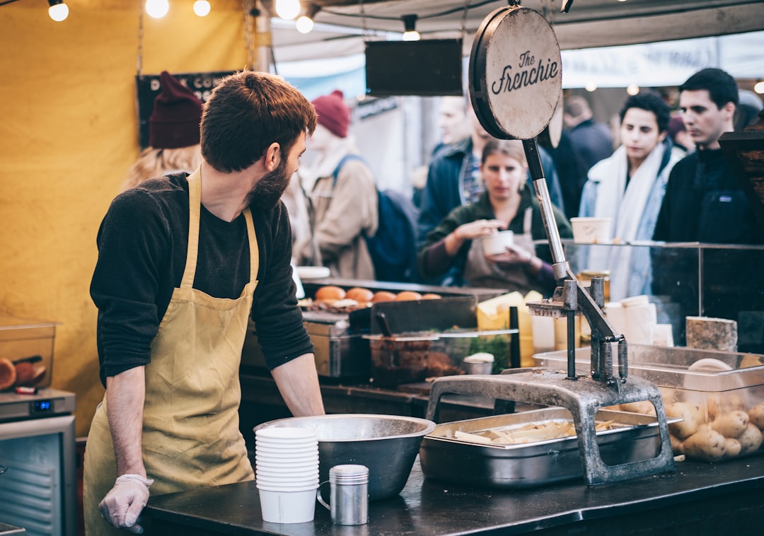 A vendor hands a customer fresh street food at Borough Market, one of London's most celebrated street food destinations.
