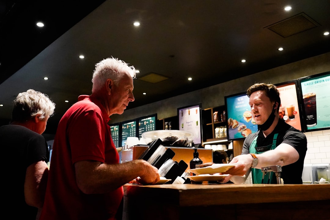 A man purchasing tickets at the counter of one of London's independent London cinemas, smiling at the staff member