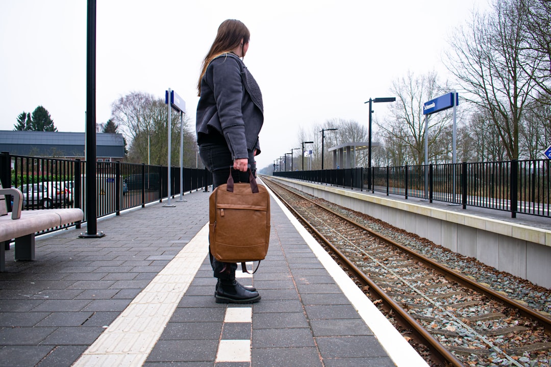 A woman steps off a train at a historic British station platform, ready to begin one of her weekend escapes from London.