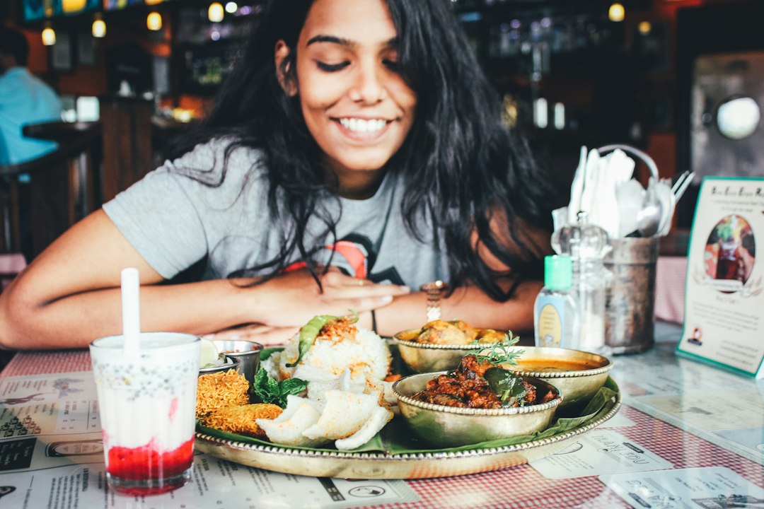 A woman sharing an Ethiopian restaurants injera platter at a table with friends in London