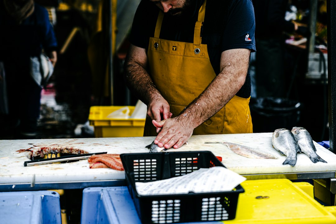 Fishmonger serving a customer at Brixton Market's Electric Avenue stalls